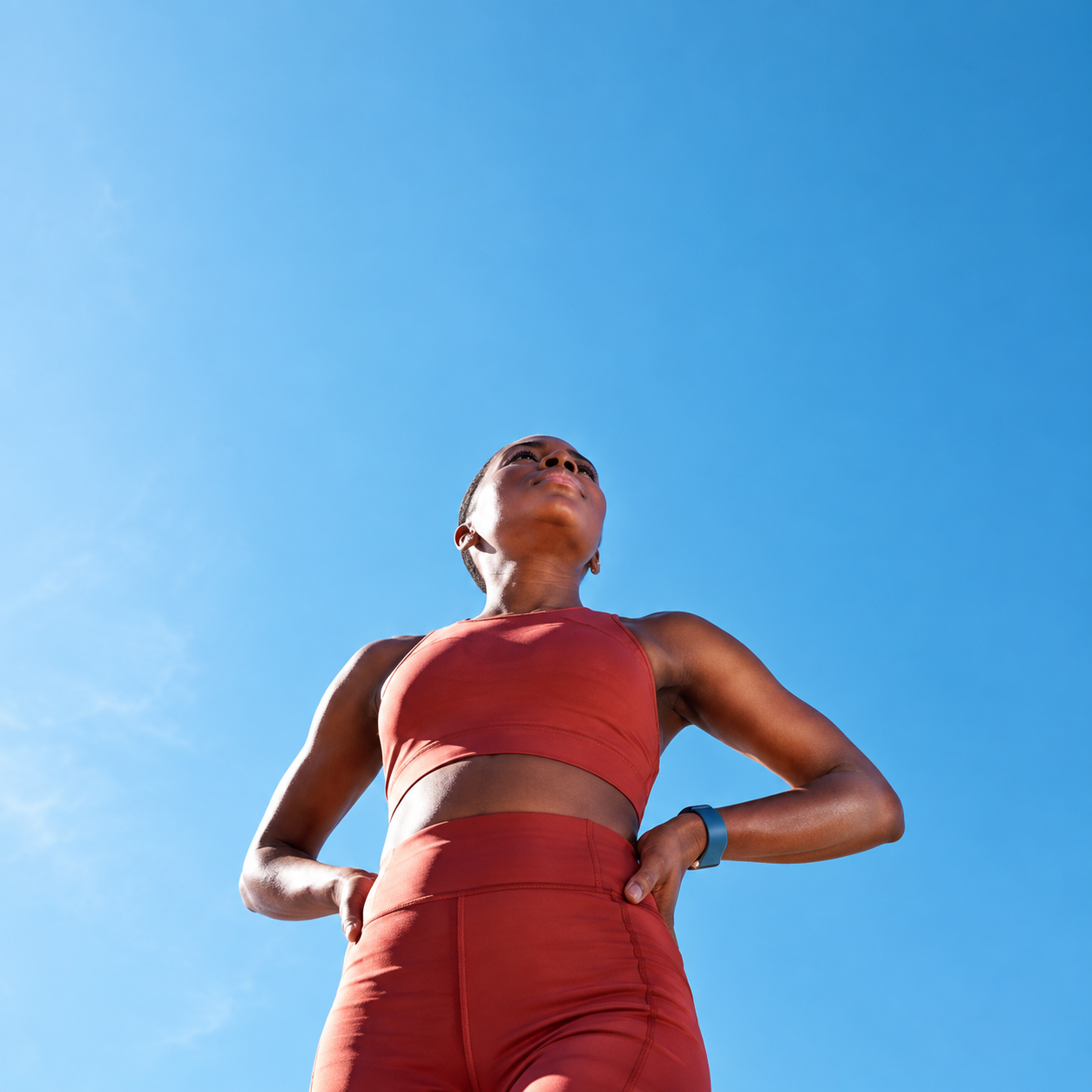 Athlete standing against a clear blue sky