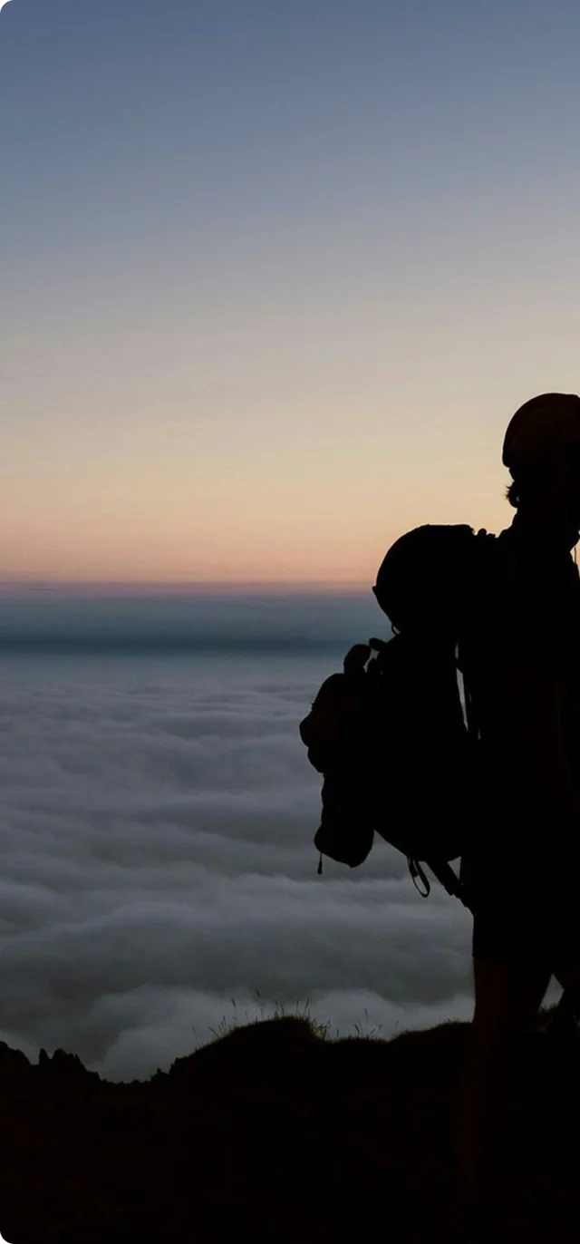 A hiker looking across the landscape above the clouds