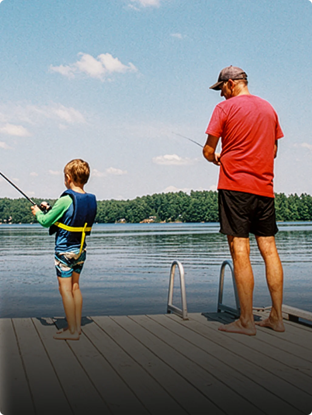 A parent and child fishing together by a lake