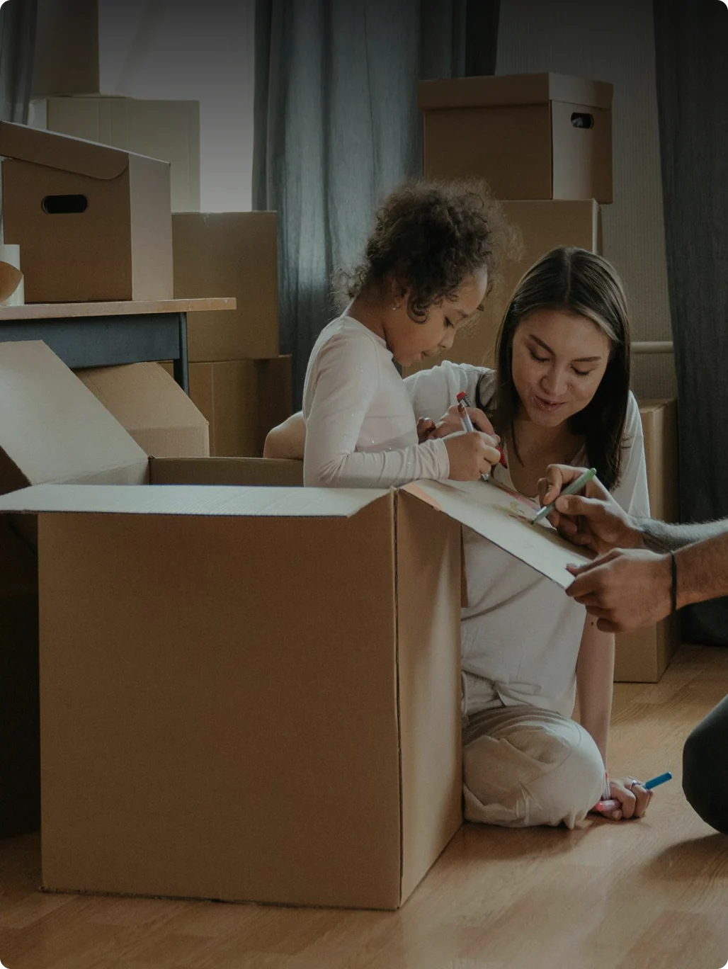 A parent and child unpacking boxes in their new home