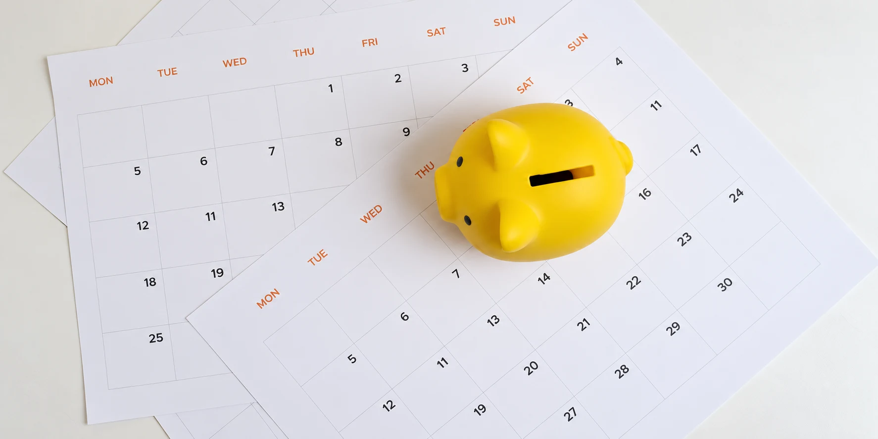 A yellow savings bank resting on calendars to represent a notice period